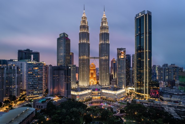 High rise buildings of Kuala Lumpur lit up at night.
